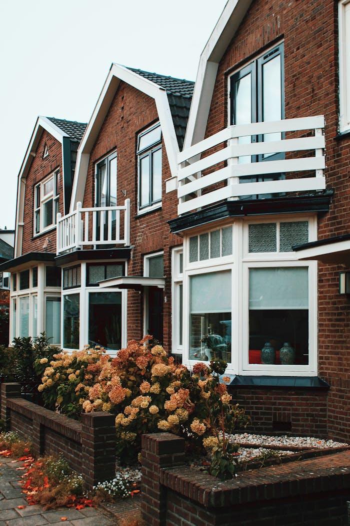 Charming brick homes in Deventer with white balconies and blooming flowers.